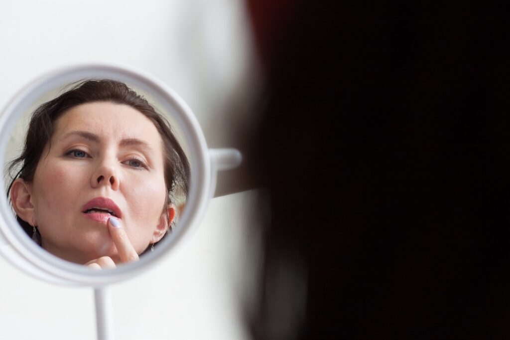 woman examining lips after office visit for lip filler near Winter Garden, Fl